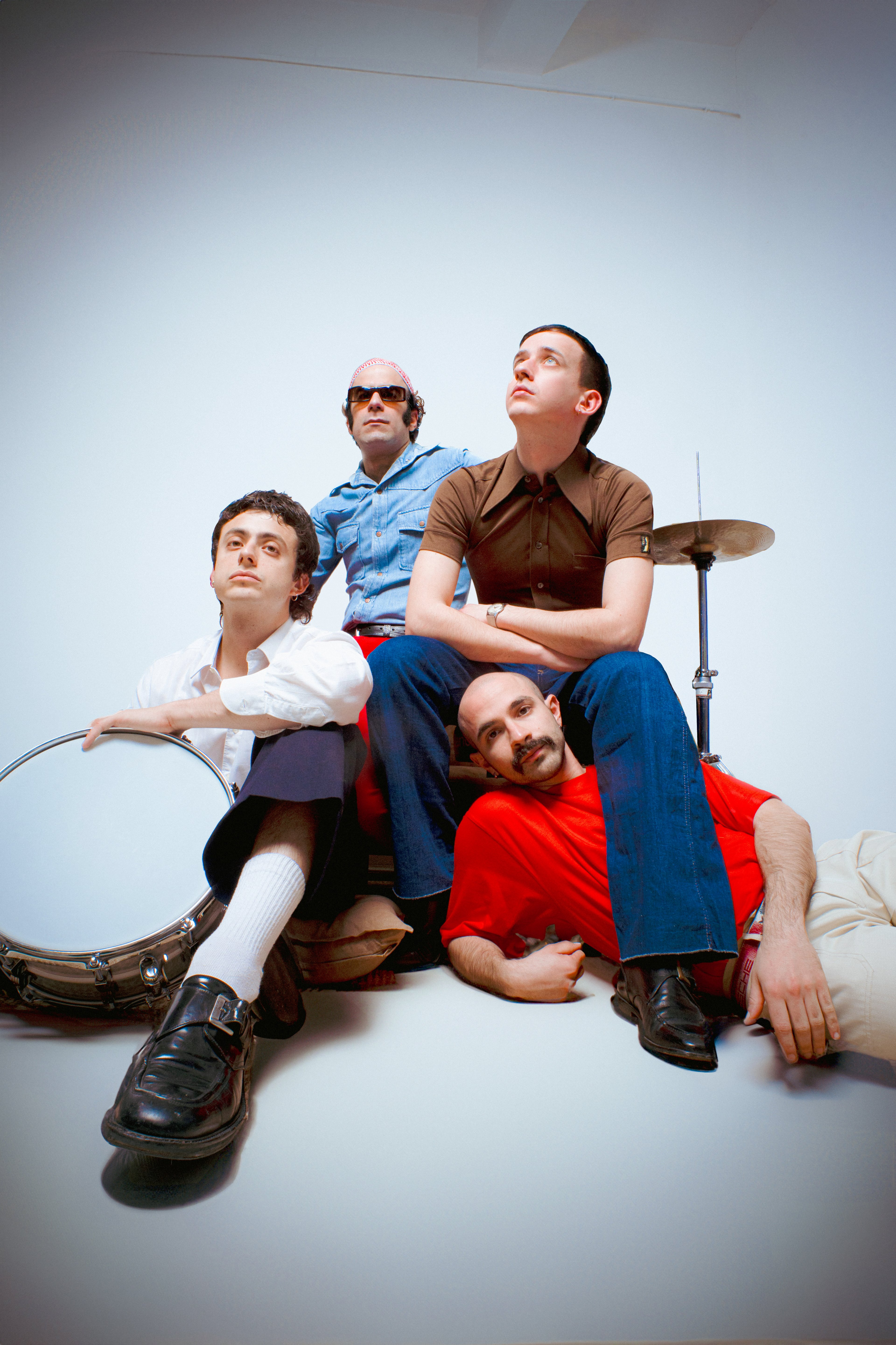 La band Il Mago del Gelato seduta su sfondo bianco.